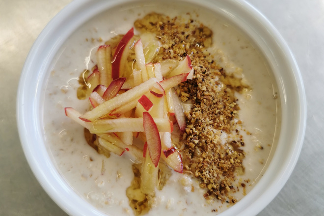 Schale mit leckerem Müsli, Joghurt und Apfelstückchen.